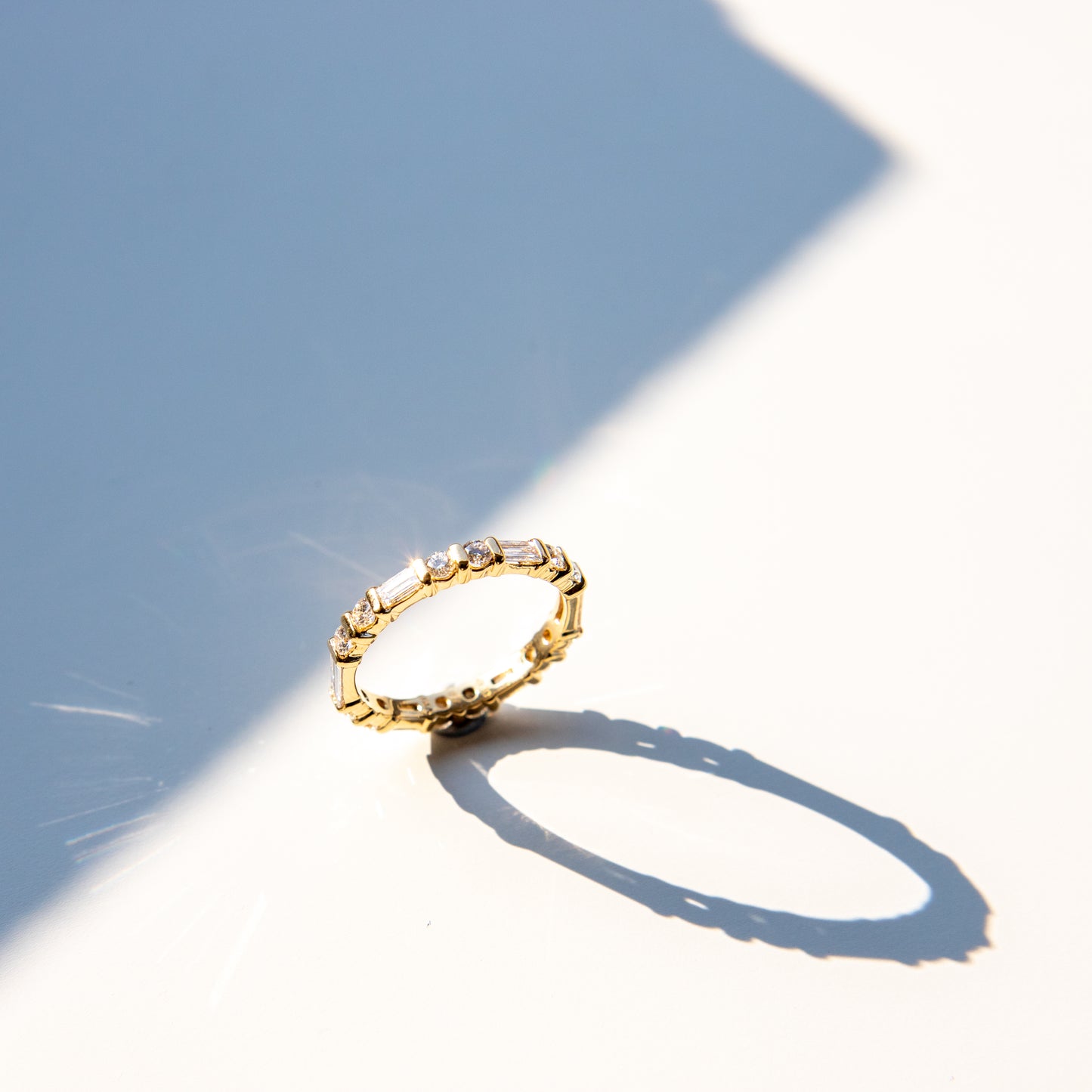 Baguette and round diamond eternity ring in yellow gold